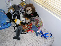 A stuffed lion, stuffed dolphins, and stuffed penguins surrounding a bunch of candy
