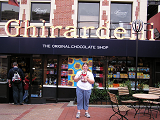 A child holding a stuffed lion in front of Ghiradelli Chocolate